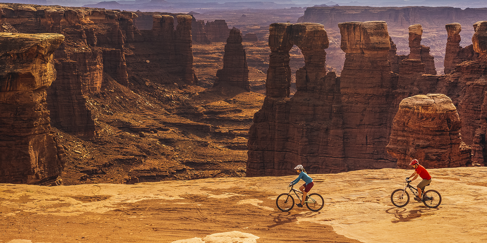 Male and female cyclist riding bikes at White Rim Trail in Canyonlands National Park